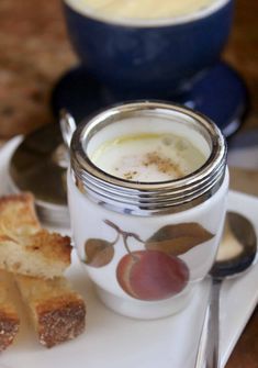 there is a plate with bread and a jar of cream next to it on the table