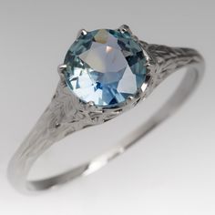 an oval blue topazte ring with filigrees on the sides, set in white gold