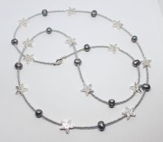 "Beautiful silver stars and gray freshwater pearls necklace. The necklace measures 36\" in length. Made using silver star beads, gray freshwater pearl beads and tiny silver tones Preciosa seed beads. Very striking and perfect for any occasion. Can be made to any length on request." Silver Pearl Beaded Dangle Necklaces, Handmade White Star-shaped Beaded Necklaces, White Star-shaped Beaded Necklaces, Cheap Star-shaped Beaded Necklaces For Gifts, White Star-shaped Adjustable Beaded Necklace, Stars Necklace, Star Beads, Long Silver Necklace, Pearls Necklace