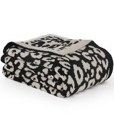 the black and white leopard print blanket is folded on top of each other, with an animal