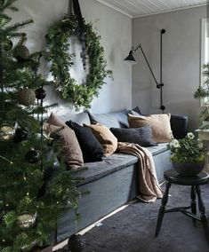 a living room filled with lots of furniture and christmas tree branches hanging from the ceiling