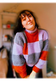 a woman is wearing a sweater and posing for the camera