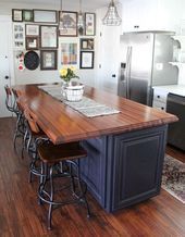 a kitchen island with stools in front of it and pictures on the wall behind it