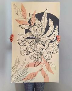 a woman holding up a large piece of art with flowers on it's back