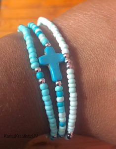 Handmade 3-piece turquoise, blue and silver plated seed beaded bracelets with blue colored cross bead (0.47 inch wide, 0.63 inch long, 0.16 inch thick). The seed beads are 3mm. Made with quality stretch cord.  Makes a great gift! Please measure your wrist before placing an order.  How to care for your bracelets:  Handle with care and please limit exposure to oils, water, fragrances, and chemicals.  See my other beautiful creations by visiting my store: https://karlaskreationz09.etsy.com Adjustable Turquoise Stretch Bracelet With Silver Beads, Nickel Free Turquoise Beaded Bracelets As Gift, Turquoise Beaded Bracelets With Silver Beads For Gift, Beaded Bracelet With Cross, Adjustable Light Blue Jewelry With Spacer Beads, Turquoise Stretch Bracelet With Colorful Beads As A Gift, Turquoise Beaded Stretch Bracelet Gift, Spiritual Turquoise Beaded Bracelets With Tiny Beads, Turquoise Friendship Bracelets With Tiny Beads As Gift