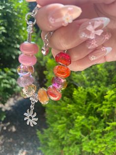 Beautiful Orange European Charm Bracelet with Sun Charm  💖 one of a kind European charm bracelet featuring a variety of unique orange charms!  💖 get ready for a ton of compliments with this stylish pink Pandora style bracelet. 💖 Bracelet measures approximately 7.5 inches in length and is adjustable  ️ please be advised this item contains small parts that may not be suitable for very small children and toddlers Orange Bracelet With Spacer Beads As Gift, Orange Round Beads Bracelets As Gift, Spiritual Orange Beaded Bracelets As Gift, Gift Orange Bracelet With Spacer Beads, Orange Bracelets With Colorful Beads For Jewelry Making, Orange Beaded Bracelets For Gift, Orange Round Beaded Bracelets For Gift, Coral Beaded Bracelets As Gift, Multicolor Charm Bracelet With Large Beads As Gift