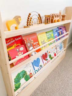 a bookshelf filled with children's books on top of carpeted floor