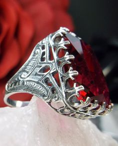 Simulated Red Ruby Ring Cardinal Design#215 Custom Made I now offer this is a brand new Art Deco reproduction ring in solid sterling silver. The gorgeous filigree ring is set with a flawless huge 30ct Man-made/simulated Red Ruby gemstone. The high-quality rectangle cut simulated Red Ruby is 20mm in length by 15mm in width (5/8th inch by 11/16th inch). the ring sits 9mm off the finger. The inside of the band is marked 925 for sterling. Notice the beautiful swirl like the craftsmanship of the silv Classic Red Ruby Ring With Vs Clarity, Collectible Red Ruby Rings, Collectible Oval Ruby Ring, Rectangular Red Ruby Ring For Formal Events, Classic Red Rings For Valentine's Day, Rectangular Hallmarked Ruby Ring, Vintage Red Rings For Valentine's Day, Classic Octagon Ruby Ring For Gift, Red Diamond Cut Rings For Gifts