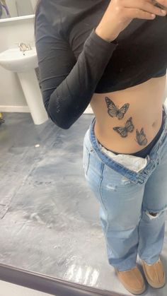 a woman taking a selfie in the mirror with butterflies on her stomach and back