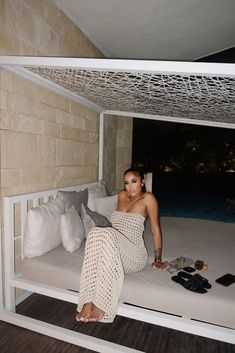 a woman laying on top of a bed next to pillows