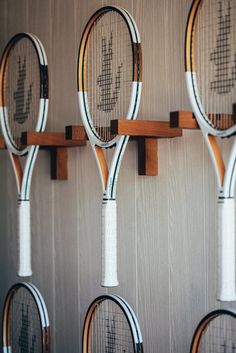 four tennis rackets are hanging on the wall