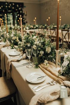 the table is set with white flowers and greenery for an elegant dinner or reception