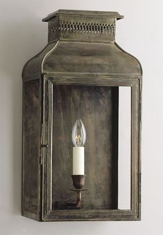 an old fashioned wall light with a candle in it