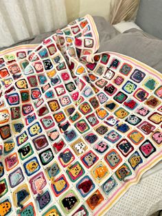 a crocheted blanket is laying on a bed