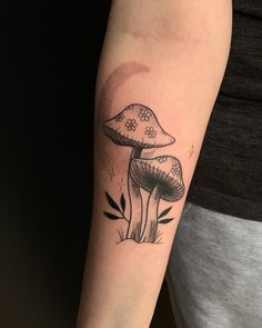 a woman's arm with a mushroom tattoo on it