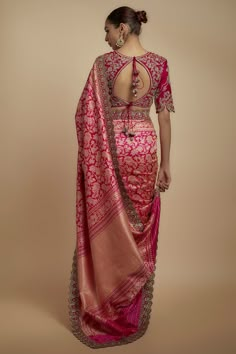 a woman in a pink and gold sari with an intricate back design on the blouse