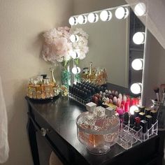 the vanity is full of cosmetics and makeup products, along with a flower vase on it