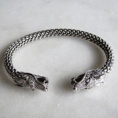 Men's bracelet made of noble material: 925 solid sterling silver. This bracelet offers a unique design. Its main part has an in relief pattern that reminds of a dragon's skins. The bracelet is set with 2 gorgeous finely worked dragon heads.  The internal circumference is 19cm (7.48in).  As silver is a flexible material, you can straighten it up or squeeze it in order to increase or decrease inner size of the bracelet and adapt it to the wist. Very elegant, it can be worn in both formal and casua Silver Bracelet For Men, Dragon Heads, Dragon Skin, Dragon Bracelet, Twisted Bracelet, Bracelet Mens, Dragon Head, Men's Bracelet, Bracelet Cuff