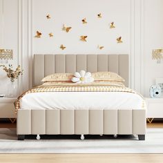 a white bed sitting in a bedroom on top of a hard wood floor next to a wall