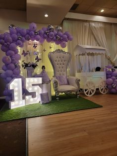 a decorated stage with balloons and chairs for a birthday party at the end of the aisle