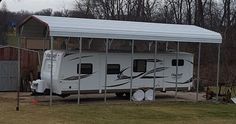 an rv is parked in front of a building with a metal roof and awning