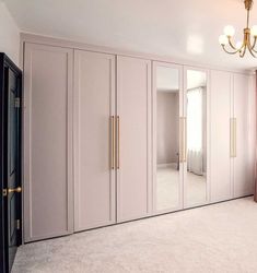 an empty room with mirrored closet doors and chandelier