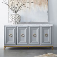 a white vase sitting on top of a gray cabinet