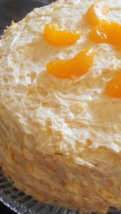 a cake with frosting and oranges on top