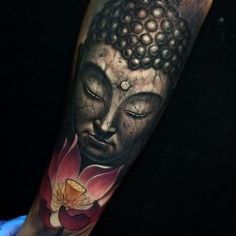 a buddha tattoo on the arm with a flower in front of it and eyes closed