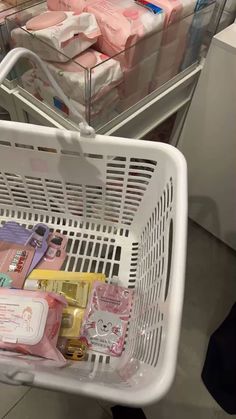 a shopping cart filled with lots of baby goods next to a pile of diapers