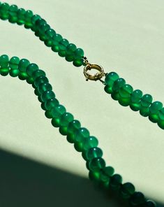 A juicy and vibrant addition to a neck-stack. This necklace is really fun and radiant - it glows when the light hits it! Handcrafted with green onyx this chunky necklace is finished with solid 14k gold findings. · Natural green onyx, 8mm, 18" long· 14k gold bold clasp + other 14k gold findings· Hand knotted with dark green silk· Stones are natural so expect some variation in color· Handmade in USA· Part of the 'Pool Party' Summer Collection· Made-to-order: Leave me a note at check-out with your desired length · Please allow 4-5 weeks for made-to-order pieces Luxury Green Onyx Beaded Necklaces, Green Onyx Necklace, Chevron Earrings, Chevron Bracelet, Chevron Necklace, Chevron Ring, Onyx Necklace, Custom Charms, Moonstone Necklace