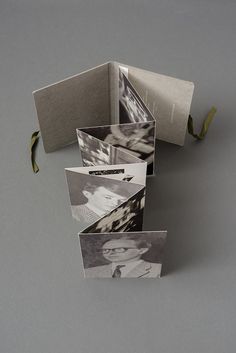 an open book with pictures inside on a gray surface