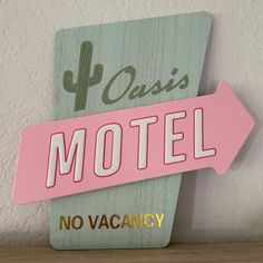 a pink sign that says oasis motel no vacancy on the side of a wall