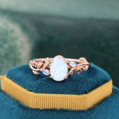 an opalite ring is sitting on top of a blue velvet hat with gold trimming