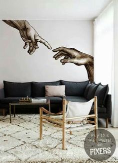 a living room with a couch, coffee table and painting on the wall that depicts two hands reaching for each other