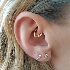 a close up of a person's ear with two piercings on it,