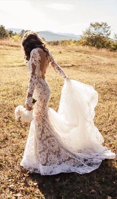 a woman in a wedding dress is walking through the grass