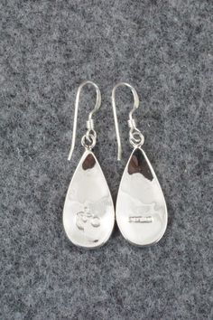 These sterling silver earrings were made by Hopi silversmith Augustine Mowa. The back is stamped sterling.Length: 1 1/2"Width: 1/2"Free shipping on all orders! We ship with USPS and always include tracking. All orders ship within a day of payment.Returns are accepted up to 30 days after you receive your order. Just send us a message. Our shop offers cash back or store credit. The item must be returned in new condition. Engraved Teardrop Earrings For Gift, Silver Teardrop Earrings With Polished Finish For Gift, Engraved Teardrop Sterling Silver Earrings, Silver Engraved Teardrop Earrings, Engraved Sterling Silver Dangle Earrings, Silver Sterling Teardrop Earrings With Polished Finish, Sterling Silver Pierced Teardrop Earrings For Anniversary, Sterling Silver Teardrop Pierced Earrings For Anniversary, Silver Sterling Silver Teardrop Earrings For Anniversary