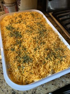 a casserole dish filled with cheese and herbs on top of a granite counter