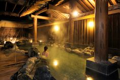 a woman is sitting in the middle of a hot tub with steam coming from it