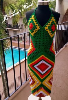 a crocheted dress is displayed on a mannequin next to a pool