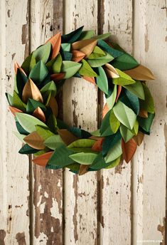 a wreath made out of paper leaves on a door