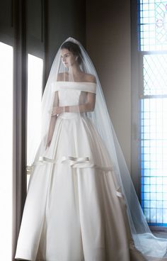 the bride is wearing a white wedding dress and veil