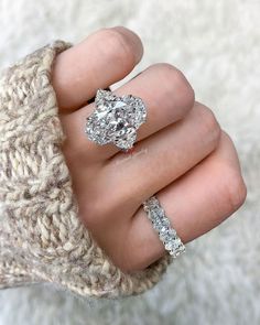 a woman's hand with two engagement rings on her fingers, and the other one has