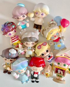 a group of small toy figurines sitting on top of a white table next to each other