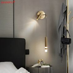 a bed room with a neatly made bed and a wall mounted light on the side