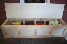 a wooden bench with storage compartments in front of a window