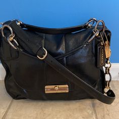 Brand New And Never Used Coach Leather Bag. Flap Pocket In Front. Interior Is A Gorgeous Fabric With Zipper Large Pocket And Two Side Pockets. Gold Notes Hardware. Retailed For $698 At Coach Store. This Is Not A Coach Outlet Bag. Some White Marks On Back Corners And Seams. I Stored It On The Floor And Honestly Forgot I Even Had It So It’s Time It Is Used And Goes To A New Home. Bottom Leather Has Some Wave To It Due To Being Stored. Photos Show This And Price Reflects The Wave And The White Mark Classic Black Hobo Bag With Metal Hardware, Designer Black Hobo Bag For The Office, Formal Black Hobo Bag With Metal Hardware, Coach Metal Hardware Satchel Shoulder Bag, Coach Satchel Shoulder Bag With Metal Hardware, Luxury Coach Shoulder Bag With Metal Hardware, Coach Shoulder Bag With Metal Hardware For Office, Black Hobo Bag With Branded Hardware And Top Handle, Chic Coach Satchel With Metal Hardware