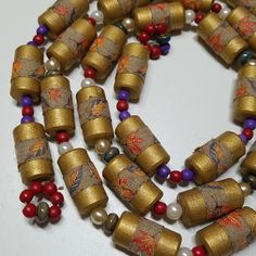 the beads have been decorated with gold and red beads