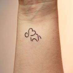 a small tattoo on the wrist of a woman's arm with an elephant symbol